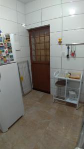 um quarto com um frigorífico e uma porta num quarto em Hostel Miscelânea em Sete Lagoas