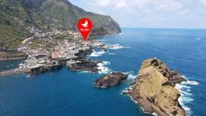 a red hot air balloon flying over the ocean at The Jolie Apartments - by the Ocean in Porto Moniz