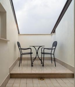 two chairs and a table in a stair case at Domus Hotel in Bagnoli del Trigno