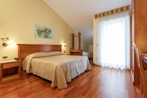 a bedroom with a bed and a large window at Domus Hotel in Bagnoli del Trigno