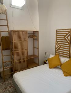 Un dormitorio con una cama con almohadas amarillas y una escalera en Casa Stella Salento - grazioso appartamento con 2 camere da letto nel cuore di Galatone, en Galatone