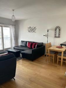 a living room with a black couch and a table at Wexford Town Centre Apartment in Wexford