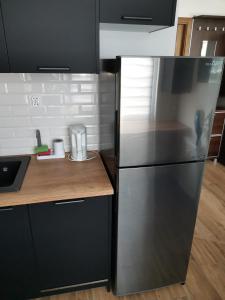 een keuken met een roestvrijstalen koelkast en een aanrecht bij Przytulny apartament w wieżowcu - Centrum miasta Podwisłocze 38 in Rzeszów