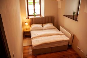 a small bed in a small room with a window at Zamkowa, Pokoje Gościnne in Kazimierz Dolny