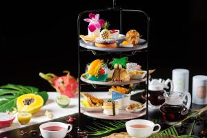 a three tiered display of pastries and cups of tea at Shin Osaka Esaka Tokyu REI Hotel in Suita