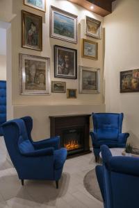 een woonkamer met blauwe stoelen en een open haard bij Albergo Rossini 1936 in Bologna
