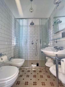 a bathroom with two sinks and a toilet and a shower at Vittorio Emanuele Top Suite in Capri