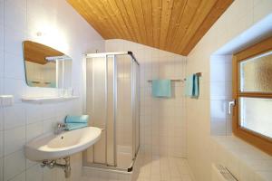 ein weißes Bad mit einem Waschbecken und einer Dusche in der Unterkunft Appartment Rettenwender in Filzmoos