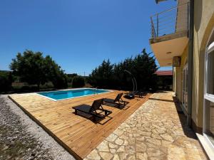 a deck with chairs and a swimming pool at Orange Tree Garden in Trogir