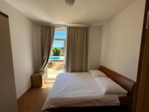 a bedroom with a bed and a large window at Orange Tree Garden in Kastel Stafilic