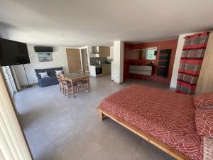 a living room with a bed and a dining room at Appartements calmes LE MAS DE LAURIANE in Saintes-Maries-de-la-Mer