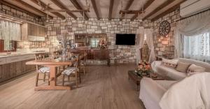 a kitchen and living room with a table and a couch at Emilia's Little Farmhouses in Agii Anargiri Milos