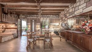 Emilia's Little Farmhouses في Agii Anargiri Milos: مطبخ كبير مع طاولة وسرير في غرفة