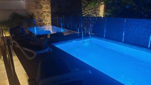 una piscina con luces azules en una casa en TORREÓN DE LA TERCIA, en Consuegra