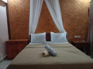 a stuffed animal is laying on a bed at Ila Homestay in Senaru