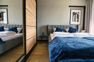 sypialnia z 2 łóżkami i lustrem w obiekcie Apartament Timi Zator by Housine w Zatorze