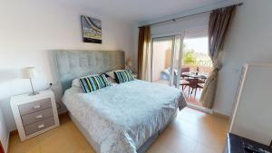 ein Schlafzimmer mit einem Bett und ein Balkon mit einem Tisch in der Unterkunft Casa Espliego D-A Murcia Holiday Rentals Property in Torre-Pacheco + 15 Fotos
