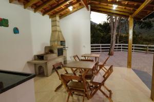 a patio with a table and chairs and a wood stove at Recanto Águas Nascentes - Casa na serra com piscina e cachoeira no quintal!! in Pedra Menina