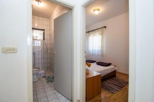 Un dormitorio con una cama y un baño con ducha. en Apartments Goran near the beach, en Srima 69 fotos más