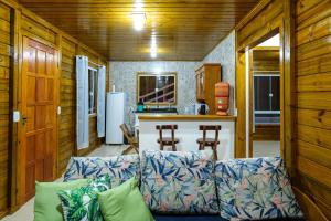 a living room with a couch and a kitchen at Recanto Águas Nascentes - Casa na serra com piscina e cachoeira no quintal!! in Pedra Menina +71 photos