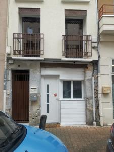 une maison blanche avec 2 balcons et un garage blanc dans l'établissement Sweet Loft Grenoble-Love Room avec jacuzzi & sauna, à Grenoble