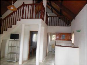 a living room with a staircase in a house at SNI-Village Ambohidratrimo au bord du Lac Andranotapahana in Ambohidratrimo