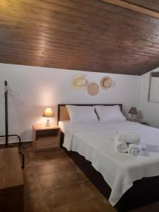 1 dormitorio con 1 cama con 2 toallas en MAD'S Villas, en Nea Peramos