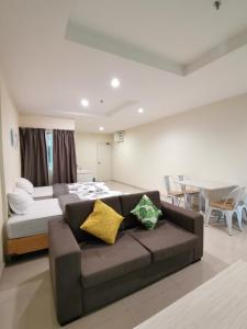 - une chambre avec un canapé, un lit et une table dans l'établissement Peaceful 1-bedroom unit at Marina Island by JoMy Homestay, à Lumut