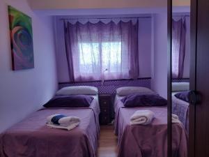 1 dormitorio con 2 camas y toallas. en Piso a 20 minutos del centro Madrid con wifi, en Navalcarnero
