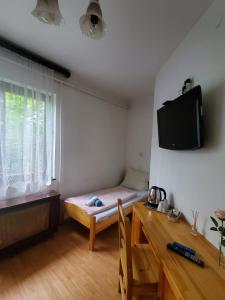 希歐福克的住宿－Liget Üdülő Siófok，小房间设有一张床和墙上的电视