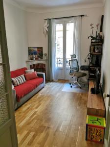 uma sala de estar com um sofá vermelho e uma secretária em Our home, Cozy Apartment two minutes from the sea - Clima em Nice