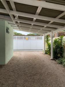 a garage with a white gate and a white fence at Casa da Vila in Porto Belo