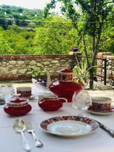 einen Tisch mit rotem Geschirr und einer Teekanne darauf in der Unterkunft Guest house Babaka in Sighnaghi