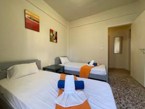 a hotel room with two beds with towels on them at Villa California in Paralia Dionysiou