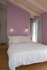A bed or beds in a room at Residence CaFelicita - Promotion - Apartments Lake View - Infinity Pool - Jacuzzi