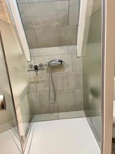 a shower with a glass door in a bathroom at Olive Bed and Breakfast in Amsterdam