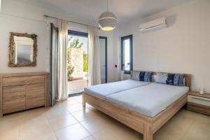 a bedroom with a bed and a mirror and a window at Sea Whisper Villa in Peloponnese in rkadiko Chorio