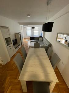 a living room with a table and a couch at Apartman CITY CENTER 4-šetalište in Prijedor