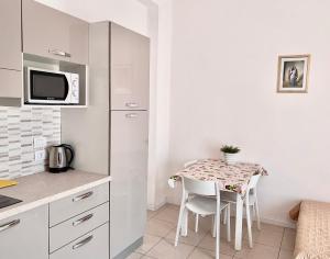 a small kitchen with a table and a microwave at Santa Barbara hotel & apartments in Bellaria-Igea Marina