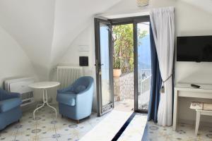 a living room with a blue chair and a sliding glass door at Guest House Malù in Scala