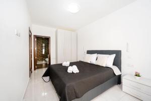 a bedroom with a large bed with two towels on it at Vela Blu Apartments - Rose Court in Il-Gżira