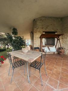 a table and chairs on a patio with a bed at Bed & Breakfast Le Coccinelle in Rosciano