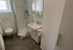 y baño con lavabo, ducha y aseo. en Haus Kiek Ut Apartment 23, en Timmendorfer Strand