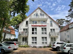 een groot wit gebouw met een bord erop bij Haus Niedersachsen Apartment 12 in Timmendorfer Strand