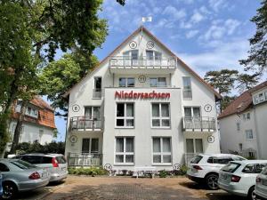 um grande edifício branco com um cartaz em Haus Niedersachsen Apartment 12 em Timmendorfer Strand