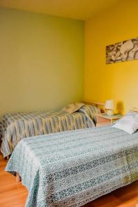two beds in a room with yellow walls at Bed & Breakfast Le Coccinelle in Rosciano