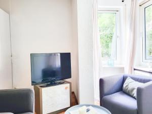 un soggiorno con TV e divano blu di Gästehaus an der Moseltherme a Traben-Trarbach