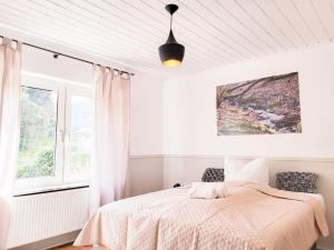 a white bedroom with a bed and a window at Gästehaus an der Moseltherme in Traben-Trarbach