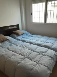 a bedroom with two beds and a window at BRISAS DEL MAR II in Formentera del Segura