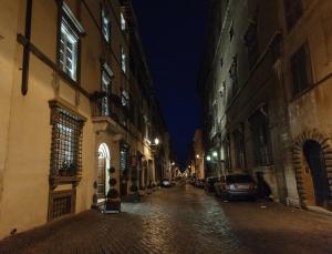 an empty city street at night with cars parked at Relais Giulia in Rome